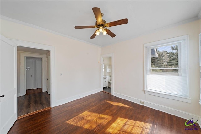 spare room with dark wood-style floors, baseboards, a ceiling fan, and crown molding