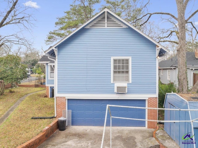 view of side of home featuring a garage, concrete driveway, and brick siding