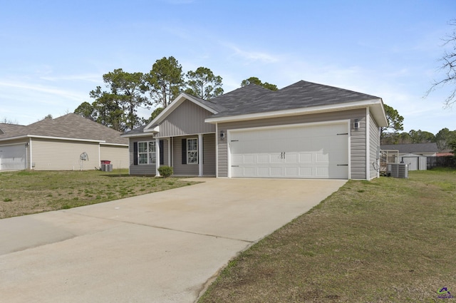 ranch-style house featuring a garage, a front yard, driveway, and central air condition unit