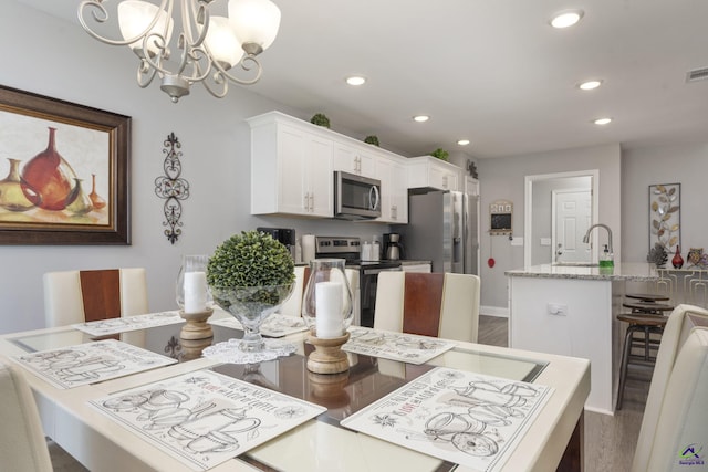 dining room featuring baseboards, wood finished floors, visible vents, and recessed lighting