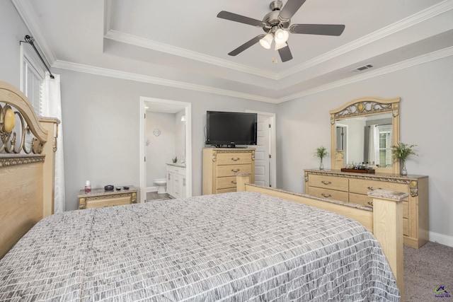 carpeted bedroom with visible vents, a raised ceiling, ceiling fan, ensuite bath, and crown molding