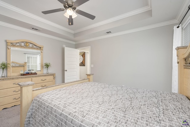 bedroom featuring ceiling fan, a raised ceiling, visible vents, and crown molding