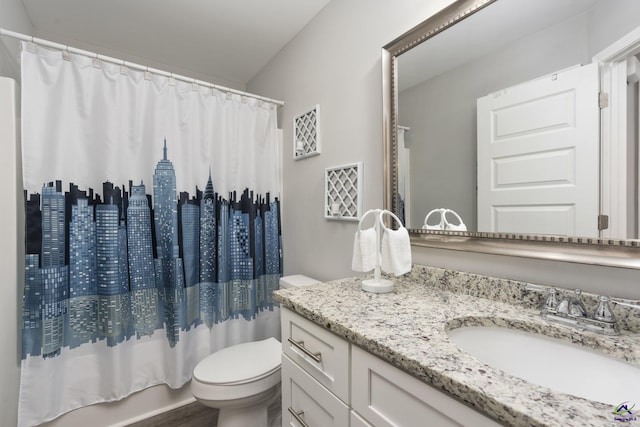 full bathroom with shower / tub combo with curtain, vanity, and toilet