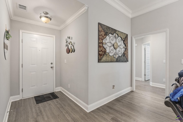 foyer featuring baseboards, wood finished floors, visible vents, and crown molding