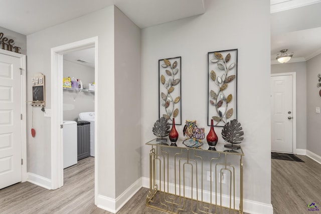 corridor featuring baseboards, separate washer and dryer, and wood finished floors