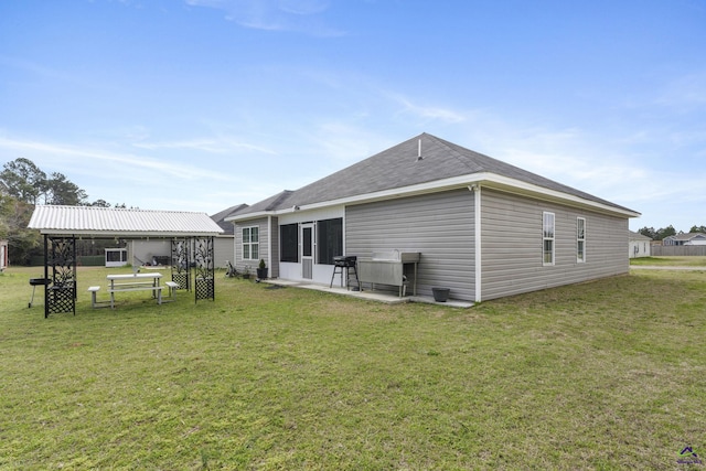 rear view of house with a patio and a yard