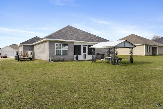 rear view of house featuring a yard and a gazebo