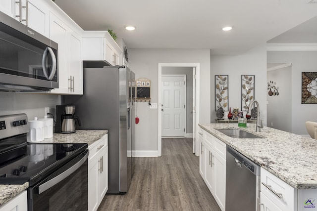 kitchen featuring white cabinets, light stone counters, dark wood-type flooring, stainless steel appliances, and a sink