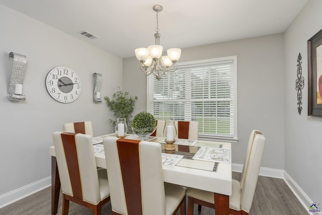 dining room featuring visible vents, dark wood finished floors, baseboards, and an inviting chandelier