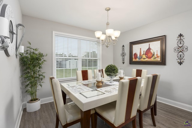 dining space featuring dark wood-style floors, baseboards, and an inviting chandelier