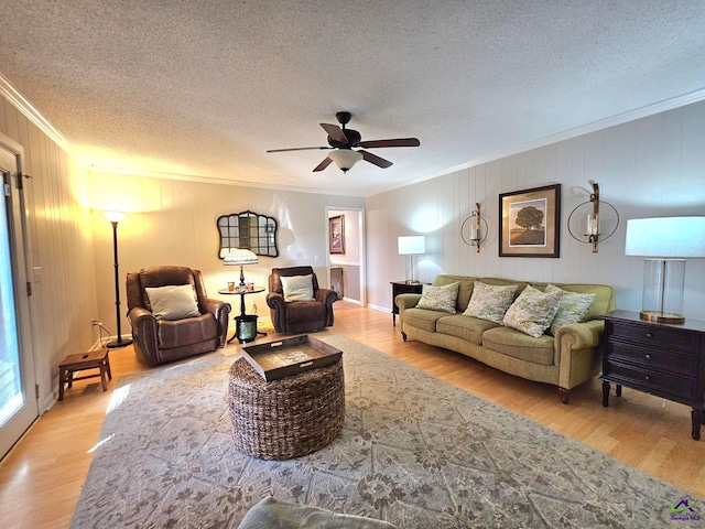 living area with crown molding, a textured ceiling, and wood finished floors