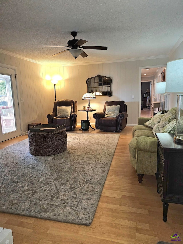 living room featuring ornamental molding, a textured ceiling, and wood finished floors