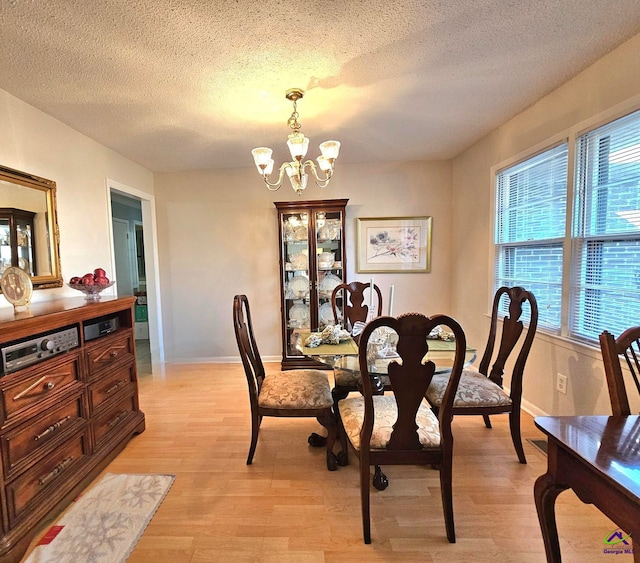 dining area with an inviting chandelier, baseboards, and light wood finished floors