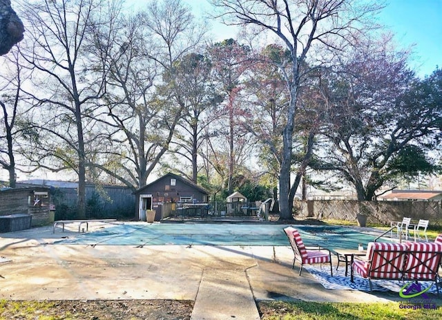 pool featuring fence and a patio