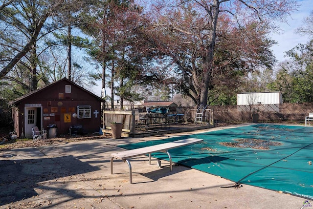 view of pool with a fenced in pool, an outbuilding, a patio area, and fence