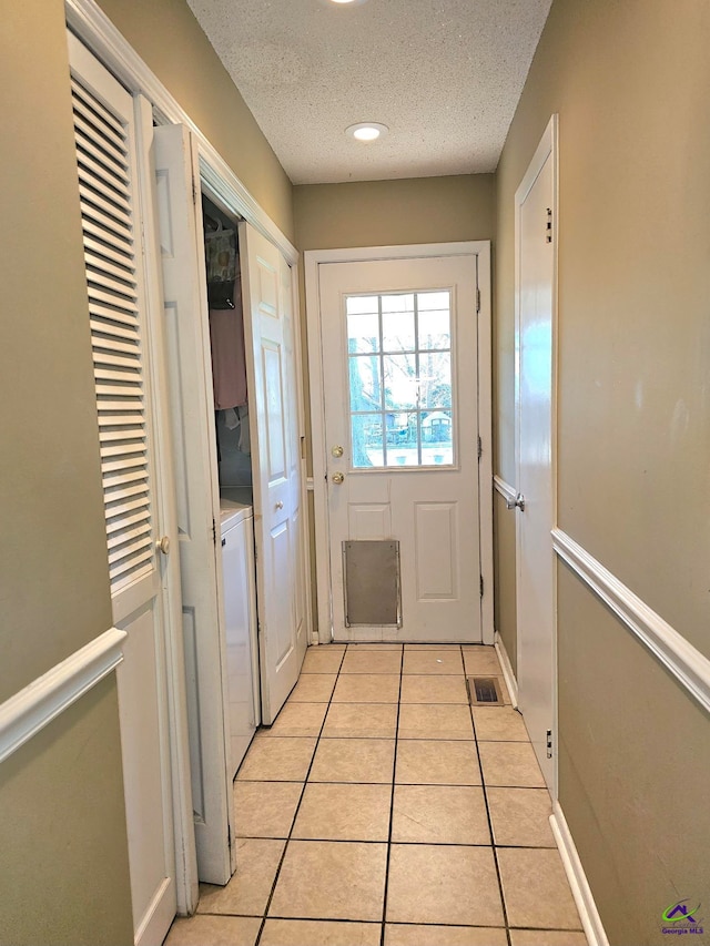 doorway featuring recessed lighting, visible vents, a textured ceiling, and light tile patterned flooring