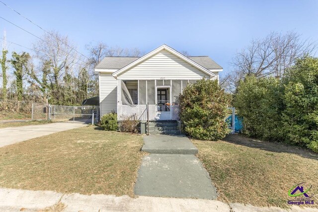 2137 Mutual Ave, Macon, GA 31204 - bungalow featuring concrete driveway, a sunroom, fence, a front lawn, and a carport