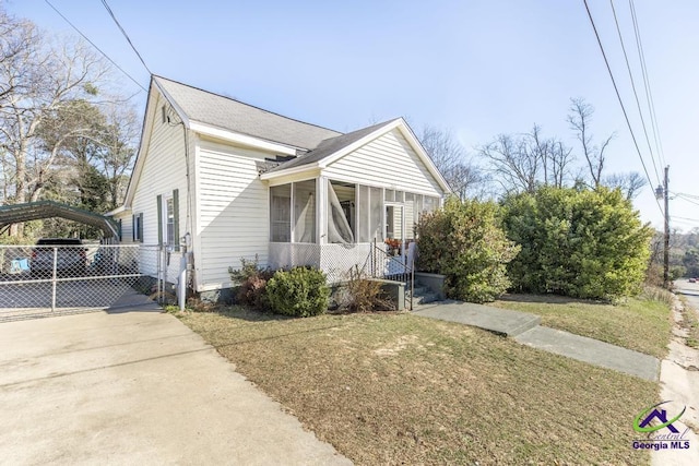 2137 Mutual Ave, Macon, GA 31204 - view of front of home featuring a front yard, a sunroom, fence, a carport, and driveway