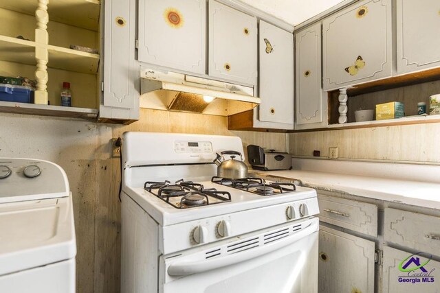 2137 Mutual Ave, Macon, GA 31204 - kitchen featuring gas range gas stove, open shelves, light countertops, washer / dryer, and under cabinet range hood