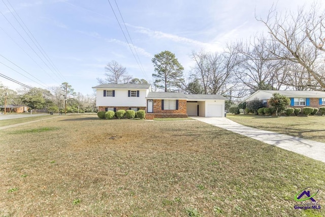 tri-level home featuring driveway, a garage, a front yard, and brick siding