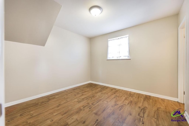 unfurnished room featuring baseboards and wood finished floors