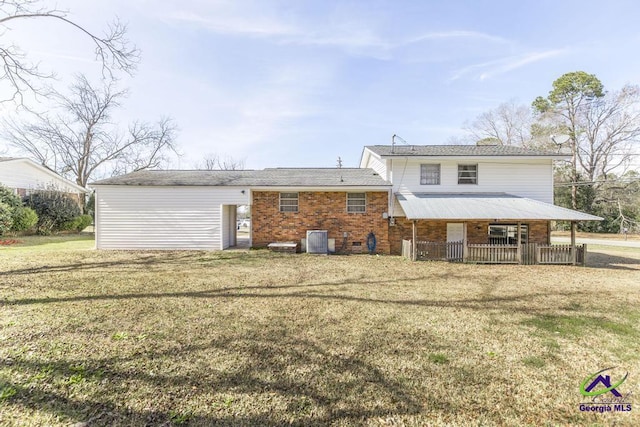 rear view of property featuring brick siding, central AC, and a yard