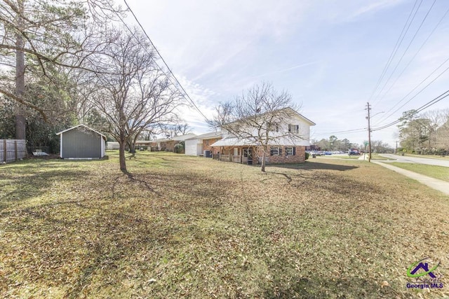 view of front of property with an outbuilding, brick siding, a shed, and a front yard