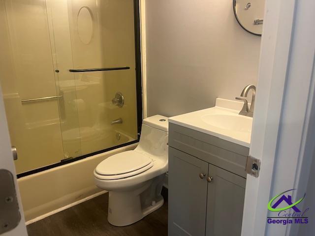324 Jefferson Park Dr, Macon, GA 31220 - bathroom featuring bath / shower combo with glass door, vanity, wood finished floors, and toilet