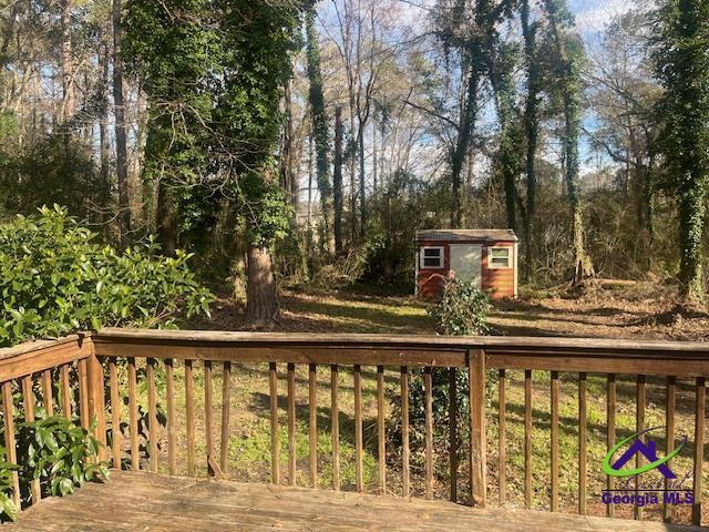 324 Jefferson Park Dr, Macon, GA 31220 - wooden terrace featuring a storage unit and an outbuilding