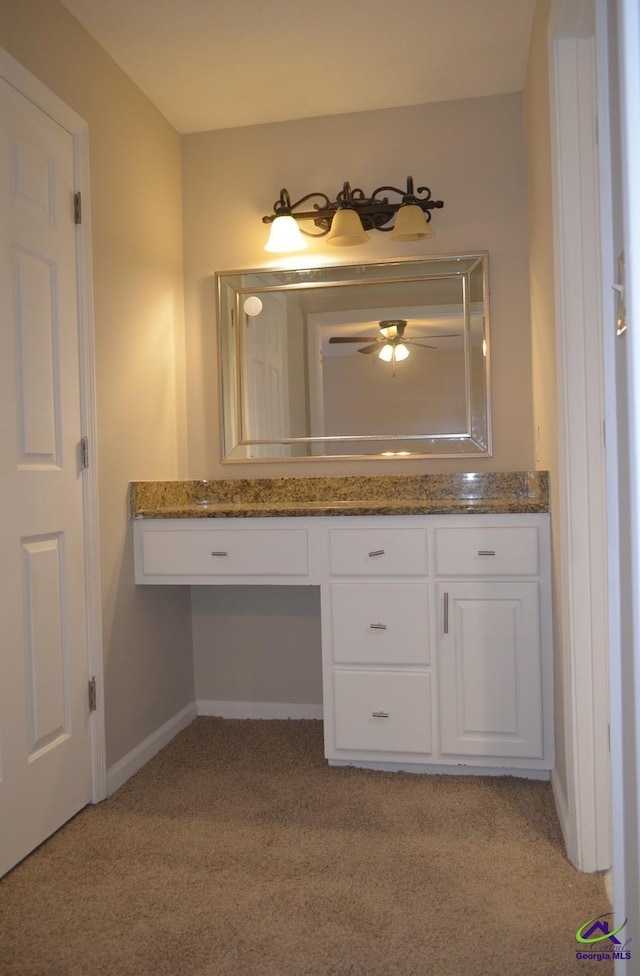 bathroom featuring ceiling fan, baseboards, and vanity