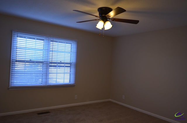 empty room featuring a ceiling fan, baseboards, visible vents, and carpet flooring