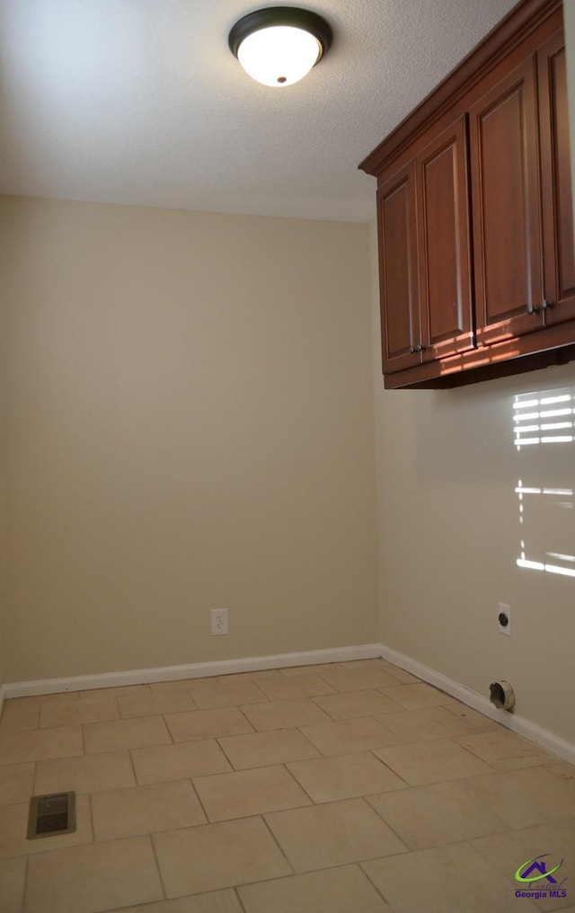 clothes washing area featuring cabinet space, baseboards, visible vents, a textured ceiling, and hookup for an electric dryer