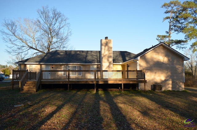 rear view of property with a chimney, a wooden deck, a lawn, and central air condition unit