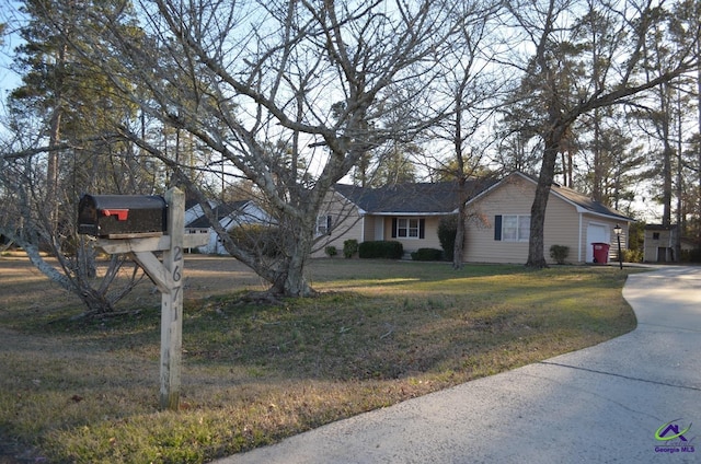 view of front of house with a garage, a front lawn, and concrete driveway