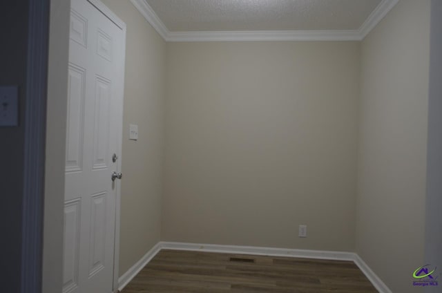 unfurnished room featuring baseboards, dark wood finished floors, and crown molding