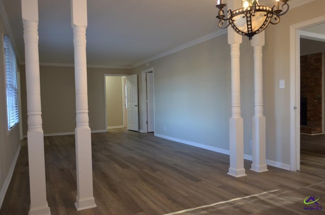 spare room with dark wood-style floors, baseboards, a chandelier, and ornamental molding