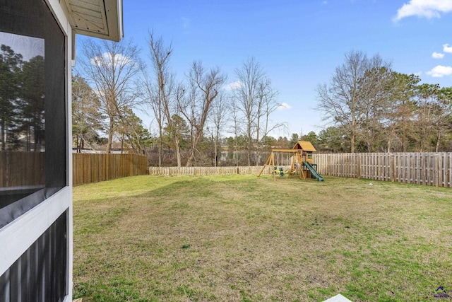 view of yard with a fenced backyard and a playground