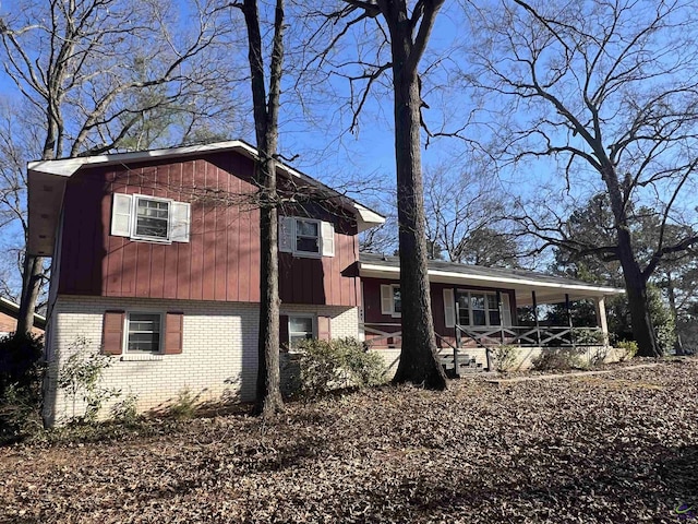 view of front facade featuring a porch, board and batten siding, and brick siding