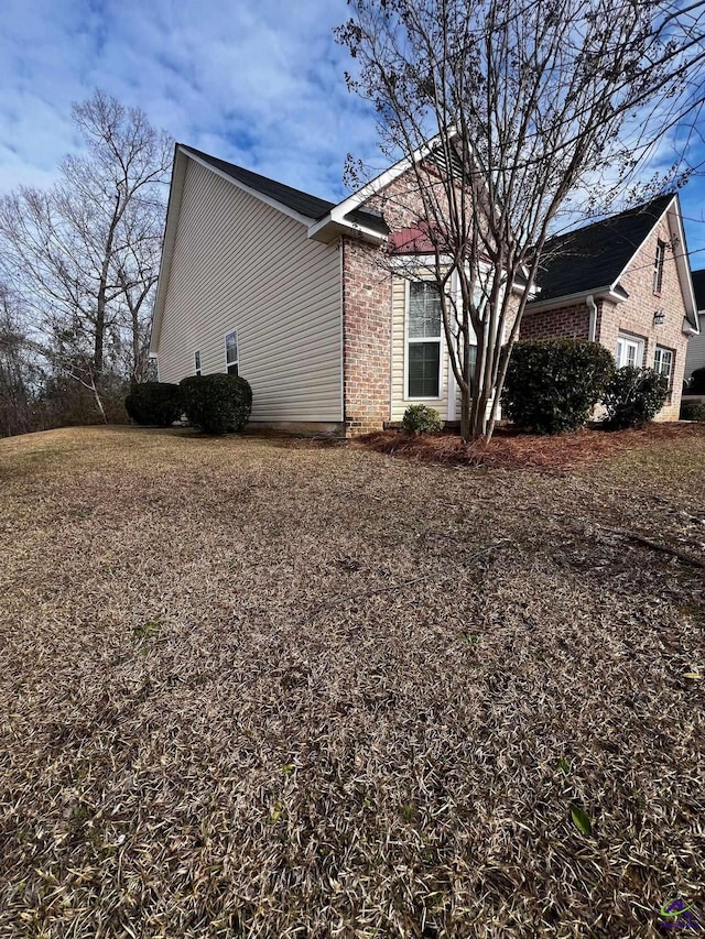 view of side of home featuring brick siding