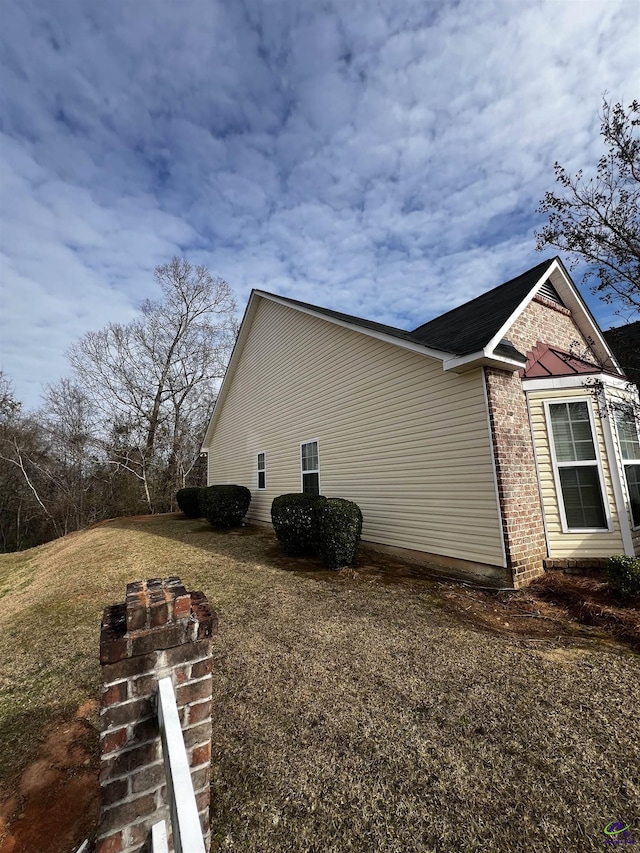 view of side of home with a lawn