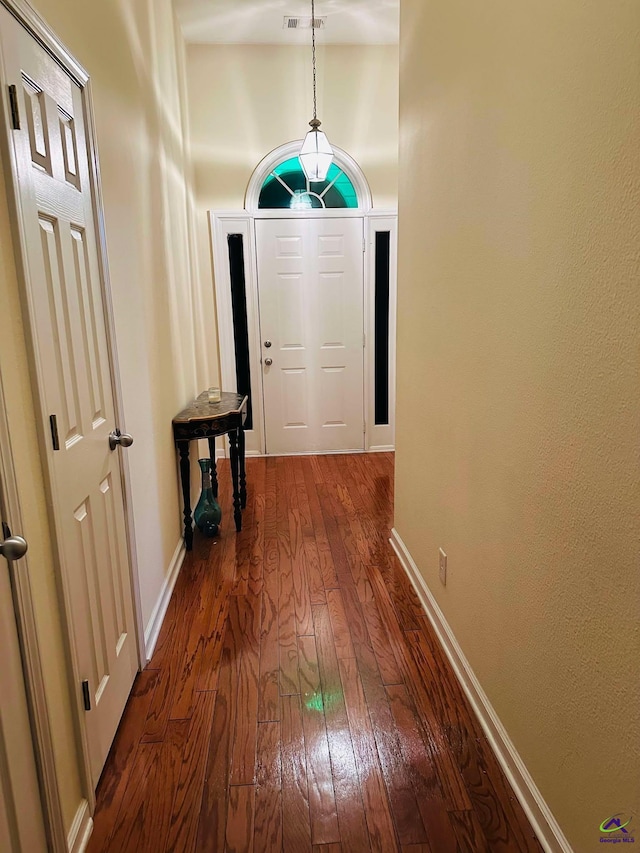 entryway with dark wood-style flooring and baseboards