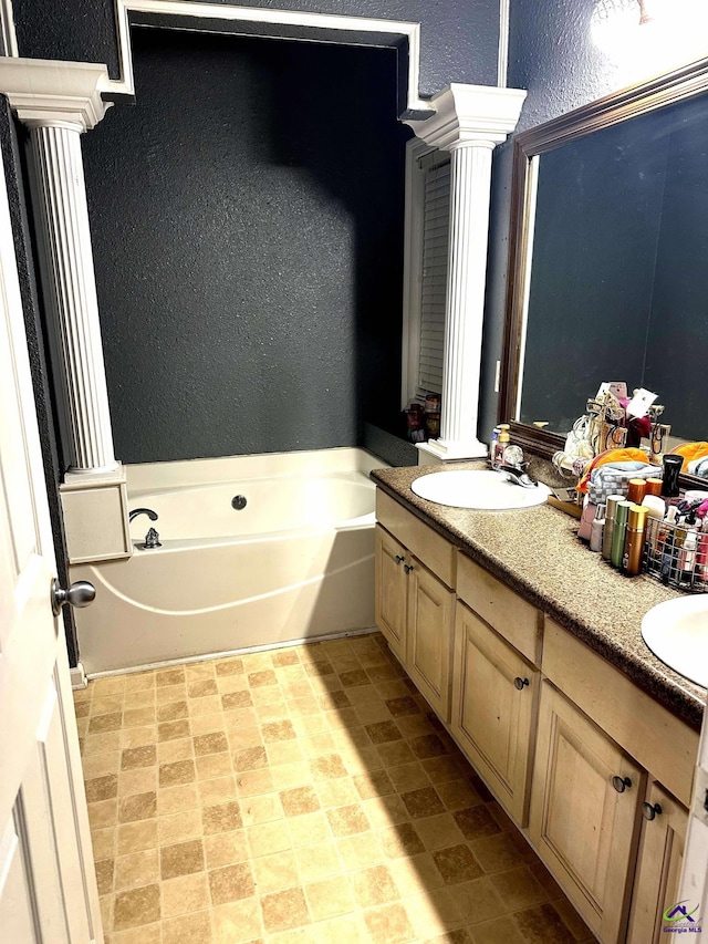 bathroom featuring a textured wall, a garden tub, a sink, and double vanity