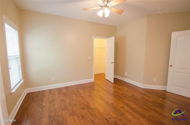 unfurnished bedroom featuring multiple windows, baseboards, and wood finished floors