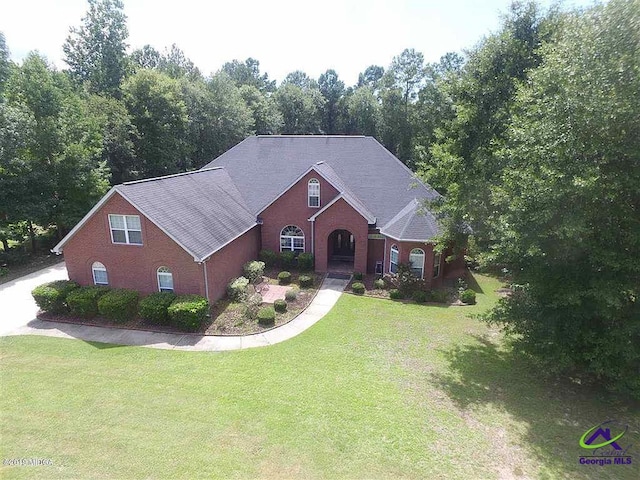 view of front of house featuring a front lawn and brick siding