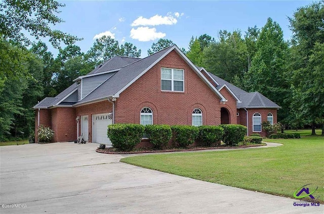 view of front facade featuring driveway, a front yard, and brick siding