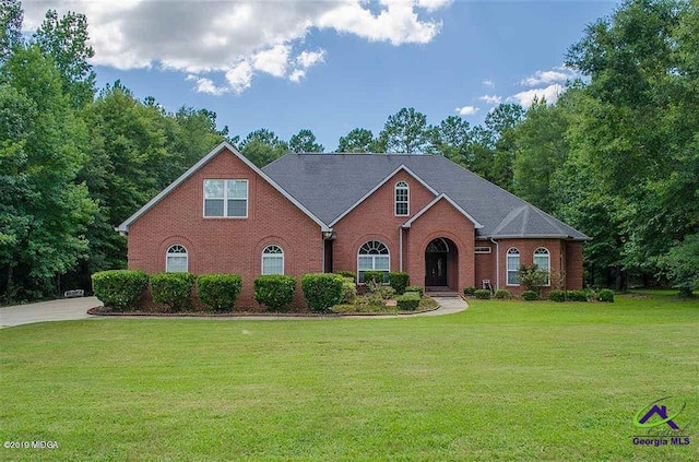 traditional-style house with a front yard and brick siding