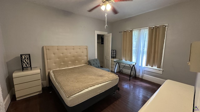 bedroom with baseboards, a ceiling fan, and dark wood-type flooring