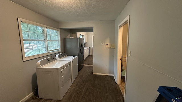 laundry area with dark wood-type flooring, baseboards, washer and clothes dryer, and a textured ceiling