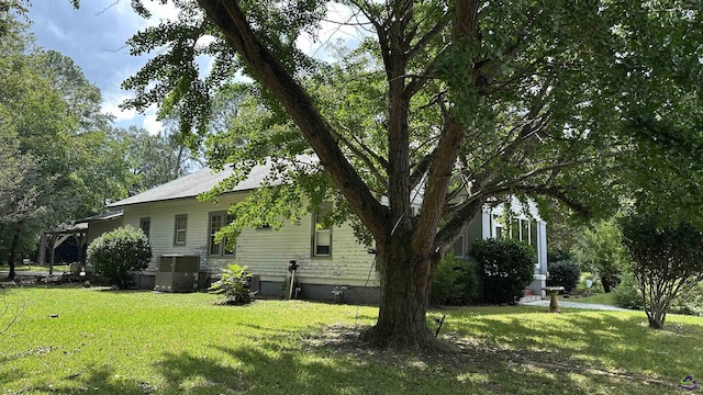 view of side of home featuring crawl space, a lawn, and central air condition unit