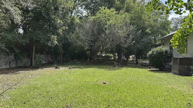 view of yard featuring cooling unit and fence